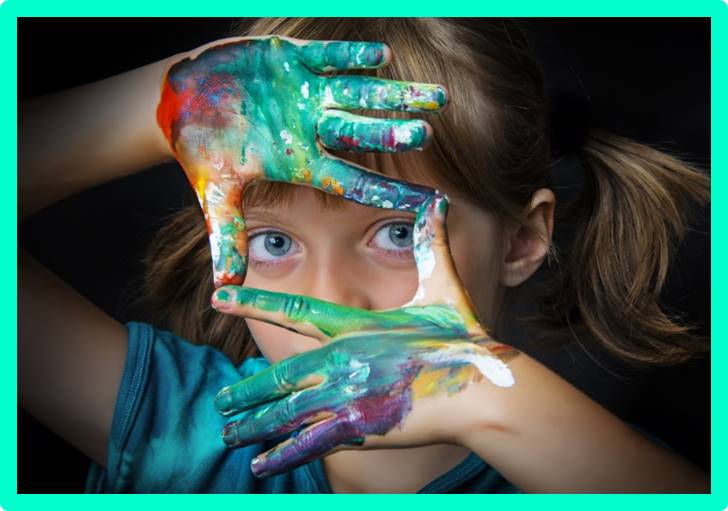 Niña con manos pintadas durante una actividad de arte